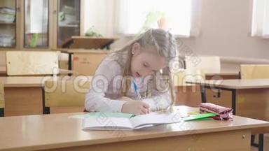 小女孩坐在学校的班级里学习。